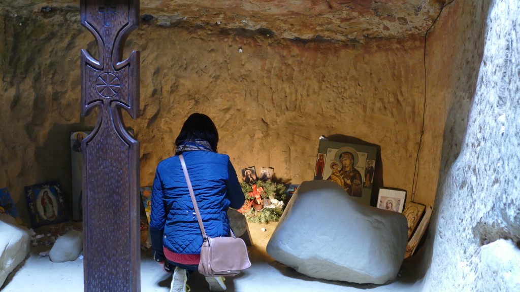 Biserica Rupreste at Sinca Vecha. Woman is praying