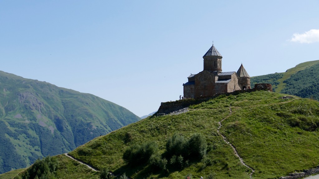 Gergeti Trinity Church (Georgian: წმინდა სამება - Tsminda Sameba) is a popular name for Holy Trinity Church near the village of Gergeti in Georgia. The church is situated on the right bank of the river Chkheri at an elevation of 2170 meters, under Mount KazbeK. The Gergeti Trinity Church was built in the 14th century. Its isolated location on top of a steep mountain surrounded by the vastness of nature has made it a symbol for Georgia. The 18th century Georgian author Vakhushti Batonishvili wrote that in times of danger, precious relics from Mtskheta, including Saint Nino's Cross were brought here for safekeeping. During the Soviet era, all religious services were prohibited, but the church remained a popular tourist destination. The church is now an active establishment of the Georgian Orthodox and Apostolic Church